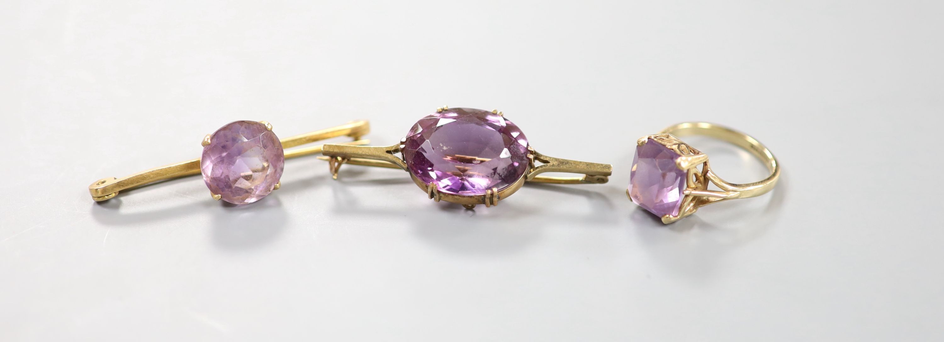 A modern 9ct gold and amethyst set dress ring and two yellow metal and amethyst set bar brooches, one stamped 9ct, gross weight 15.3 grams.